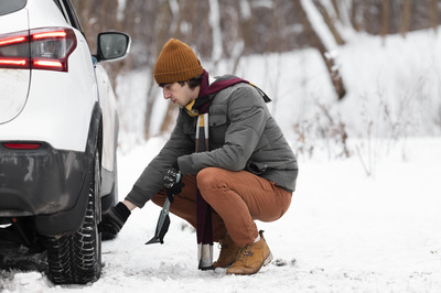 man checking tire pressurre in winter